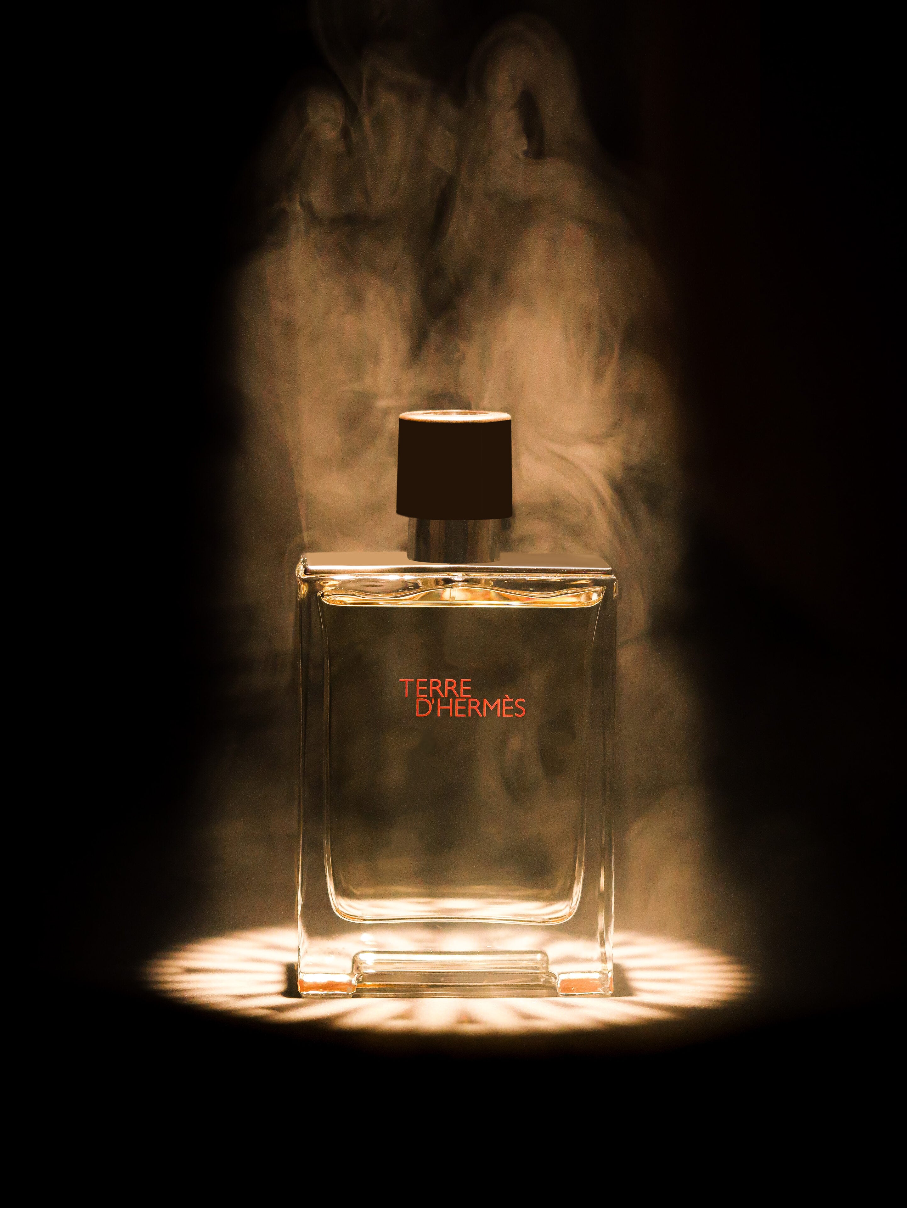 Hermès Terre d'Hermès — packshot parfum Studio Kassem Paris, lumière rasante minérale